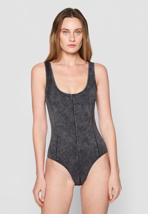 Maillot de bain noir une pièce avec un décolleté en scoop, des bretelles larges, un tissu texturé avec un léger éclat et des détails de coutures verticales.