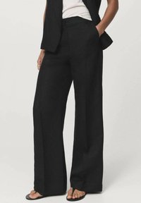 Pantalones de pierna ancha negros, confeccionados en una tela ligera, con un frente plano, bolsillos laterales y una textura suave.