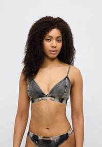 Μπραλέτα με μοτίβο τζιν σε μαύρο και γκρι, με τριγωνικά κύπελλα, λεπτές ρυθμιζόμενες τιράντες και ελαστική ταινία με λογότυπο. Λείο υφή.