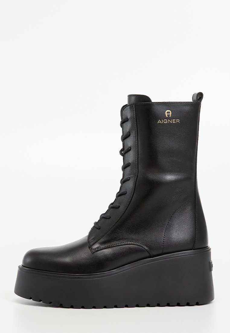 Schwarze Leder-Stiefelette mit runder Zehenpartie, Schnürung vorne und kräftiger Plateausohle. Mit dezentem Branding nahe der Oberseite.