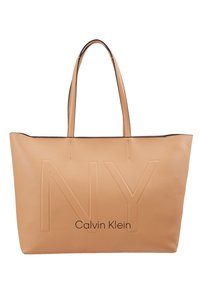 Taná veganská kožená taška s embosovaným designem "NY", logem "Calvin Klein" a dvojitými ramenními popruhy. Hladký povrch s minimem švů.