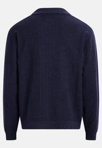 Μπλε ναυτικό πλεκτό πουλόβερ με κάθετες ρίγες, μακριά μανίκια και διπλωμένο γιακά, εμφανιζόμενο από πίσω.