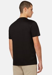 Sort kortærmet t-shirt lavet af bomuld, med rund hals, enkelt design og en glat tekstur. Ingen synlige mønstre eller accenter.