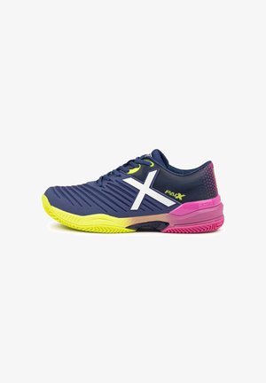 Zapatilla deportiva azul marino con suela amarillo brillante, logo lateral en forma de X blanco, talón rosa y marcas "PAX" y "MUNICH".