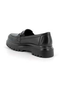 Scarpa in pelle nera con design slip-on, punta tonda e suola in gomma spessa e texturizzata. Presenta un dettaglio decorativo con cinturino e fibbia.