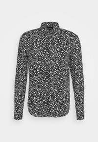 Camicia a maniche lunghe con sfondo nero, caratterizzata da un motivo astratto a onde bianche, colletto classico e chiusura con bottoni davanti.