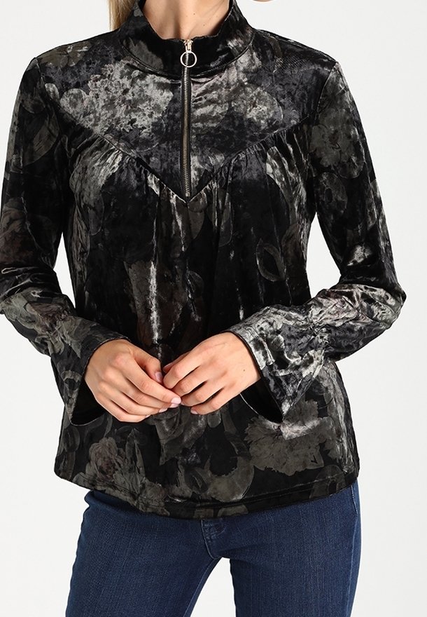 Black velvet blouse with floral pattern, high collar, front zipper, and long sleeves. Features subtle sheen and two pockets.
