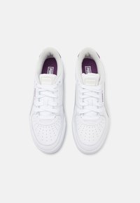 Sneaker bianche con punta perforata, materiale in pelle liscia, dettagli viola sulla linguetta e design classico con lacci.