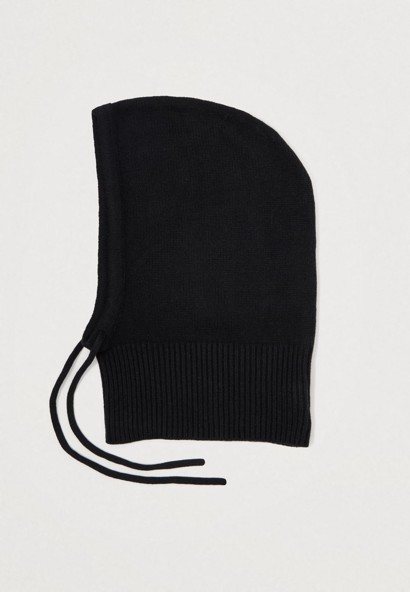 Balaclava preta em malha com uma textura suave, topo arredondado e barra canelada. Apresenta dois laços ajustáveis na base para um ajuste seguro.