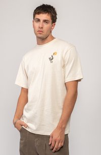 T-shirt à manches courtes couleur crème en coton doux, avec un motif de cactus et de soleil sur la poitrine gauche. Coupe relaxée avec un col rond.