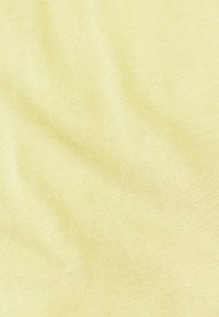 Weicher, leichter gelber Stoff mit feiner gerippter Struktur, der sanfte Wellen und subtile Farbvariationen aufweist.