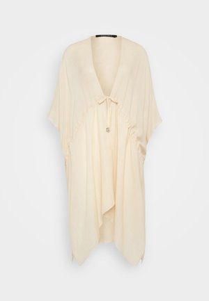 Haut léger beige avec un col en V, des manches courtes, des détails froncés et un lien à la taille. Texture douce, coupe décontractée et design drapé.