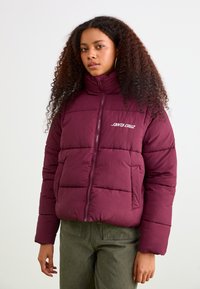 Burgundy puff jacket made from a quilted, insulated fabric. High collar, full zip, and white "Santa Cruz" logo on the left chest.