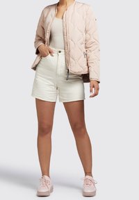 Light pink quilted bomber jacket, high-waisted white shorts, and pale pink sneakers. Jacket has zip pockets and ribbed collar.