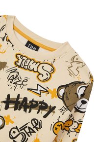 Felpa beige con stampe grafiche in nero e arancione, che presenta un orso cartone animato e elementi testuali. Girocollo e polsini a coste.