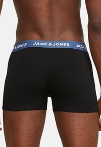 Schwarze Boxershorts aus Baumwolle mit einem blauen elastischen Bund, der das "JACK & JONES"-Logo trägt. Kurzes Bein Design mit enganliegender Passform.