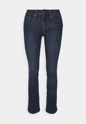 Jean en denim bleu foncé avec une coupe droite, cinq poches et des coutures renforcées. La ceinture est dotée d'une fermeture par bouton et fermeture éclair.