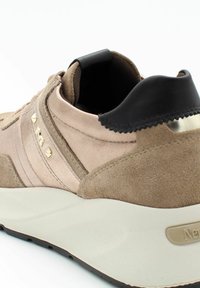 Sneakers met een taupe suède bovenkant, gouden studaccenten en een zwarte leren hiel. Kenmerken zijn een textuur middenzool en rubberen buitenzool.
