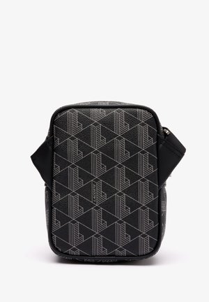 Schwarze Umhängetasche mit geometrischem, sich wiederholendem "L"-Muster und einem kleinen "Lacoste"-Label, das zentriert auf der Vorderseite angebracht ist.