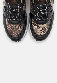 Sneakers with a black leather base and snake print canvas upper. Features metallic accents, black laces, and a white speckled sole.