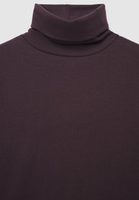Maglione a collo alto di colore viola, realizzato in un tessuto morbido e elastico, con un design aderente e un colletto alto piegato. Nessun motivo o accessorio presente.