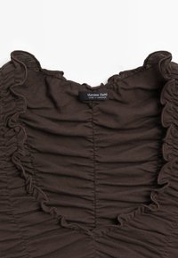 Hnědý top s volánkovým výstřihem, zdobený zhuštěnou texturou a štítkem s nápisem "Massimo Dutti." Vyrobeno z jemné, elastické tkaniny.