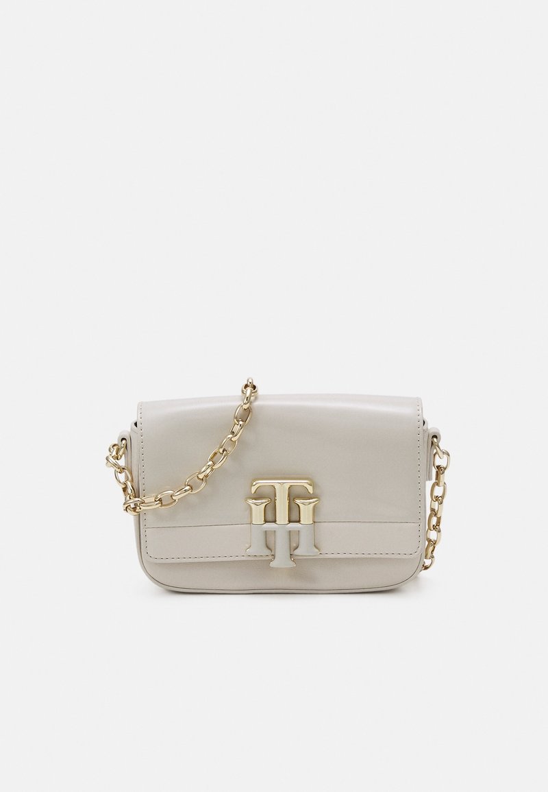 Beige leather crossbody bag with a gold chain strap and a gold hardware logo on the front. Smooth texture and rectangular shape.