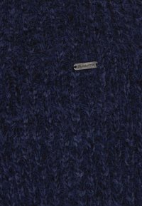 Marine gebreide trui met een gestructureerde, fuzzy uitstraling. Bevat een klein metalen label met de opdruk "DENIMASTER".
