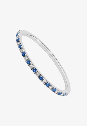 Pulsera delgada de plata con piedras azules alternando con cristales transparentes, presenta un acabado pulido y una forma suave y redondeada.