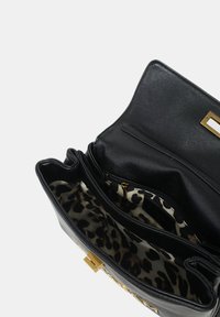 Borsa in pelle nera con interno a stampa leopardata, scomparto con zip e accessori in tono oro. Caratterizzata da diversi scomparti per una migliore organizzazione.