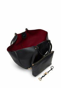 Zwarte leren tote bag met een rode binnenkant, afneembare zwarte ritszak en gouden sleutelhanger op een witte achtergrond.