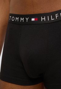 Μαύρα βαμβακερά μποξεράκια με ριγωτή υφή και ελαστική μέση με το λογότυπο "TOMMY HILFIGER" σε λευκό και μικρή διακριτική λεπτομέρεια με λογότυπο.