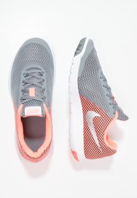 Zapatillas deportivas de malla gris con detalles en rosa, cuentan con una suela blanca, cordones grises y un logo reflectante en el lateral.