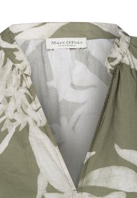 Leichte, olivgrüne Bluse mit weißem Blumenmuster, V-Ausschnitt und Falten-Details. Der Stoff wirkt weich und leicht strukturiert.