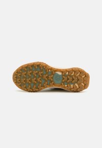 Shoe outsole with a brown rubber bottom featuring a multi-directional tread pattern, beige accents, and a teal base layer.