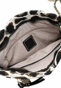 Round handbag featuring a leopard print fabric exterior in black, white, and brown, with a beige lining and a zippered pocket inside.
