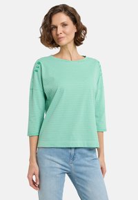 Hellgrün gestreiftes T-Shirt mit 3/4-Ärmeln, Rundhalsausschnitt und weicher Textur. Verfügt über feine Nähte an den Schultern für zusätzliche Details.