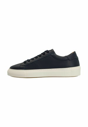 Baskets basses en cuir noir avec bout rond, semelle en caoutchouc blanche et lacets assortis. Présente un design minimaliste et des coutures contrastées.