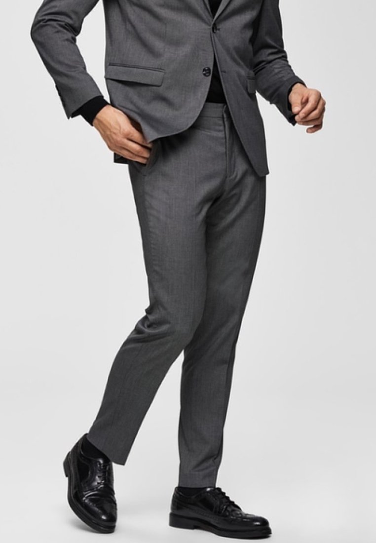 Gray suit pants made of smooth fabric, tailored fit, featuring a flat front and belt loops. Paired with black leather dress shoes.