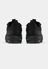 Črni pohodniški čevlji iz sintetičnega materiala, z oblazinjeno podplatom, zanke za pomoč pri obuvanju in Vibram blagovno znamko na peti. Ravna, teksturirana podplata.