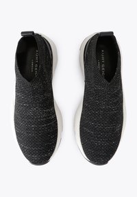 Czarne dzianinowe trampki wsuwane z kontrastową białą podeszwą, wykonane z teksturowanej tkaniny, wyposażone w pętelkę na pięcie ułatwiającą zakładanie.