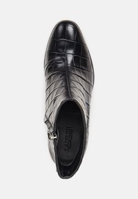 Stivale alla caviglia in pelle nera con texture coccodrillo, punta affusolata e zip laterale. Presenta una fibbia decorativa argentata sul lato.