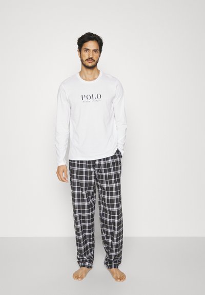 Biela košeľa s dlhým rukávom so textom "POLO RALPH LAUREN"; čierno-biele kárované pyžamové nohavice; model stojaci naboso na neutrálnom pozadí.