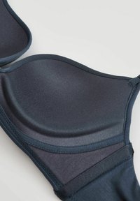 Granatowy stanik push-up z gładkimi, wyprofilowanymi miseczkami i regulowanymi ramiączkami. Posiada bezszwowy fason oraz ozdobne przeszycia wzdłuż krawędzi.