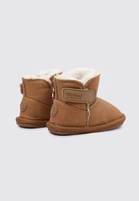 Stivaletti marroni per bambini con morbida interiore bianca, chiusura in Velcro e suola in gomma testurizzata. Punta arrotondata e dettagli cuciti. Design caldo e impermeabile.