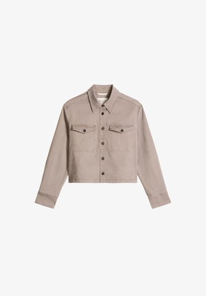 Bézs, rövidített dzseki hosszú ujjakkal, gombos elülső résszel, hegyes gallérral és két gombos mellkasi zsebbel.