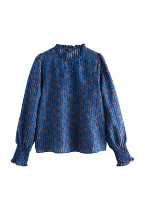 Blaue gemusterte Bluse mit langen Ärmeln, die über geraffte Bündchen, einen rüschierten Ausschnitt und ein florales Design in braunen und orangenen Farbtönen verfügt.