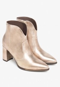 Metallisch goldene Stiefeletten mit spitzem Zeh und Blockabsatz. Glatte Lederoberfläche mit einem Ausschnittdesign und seitlichem Reißverschluss.