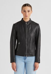 Schwarze Lederjacke mit Stehkragen, tailliertem Schnitt, sichtbarem Reißverschluss und zwei seitlichen Reißverschlusstaschen. Glatte Textur.