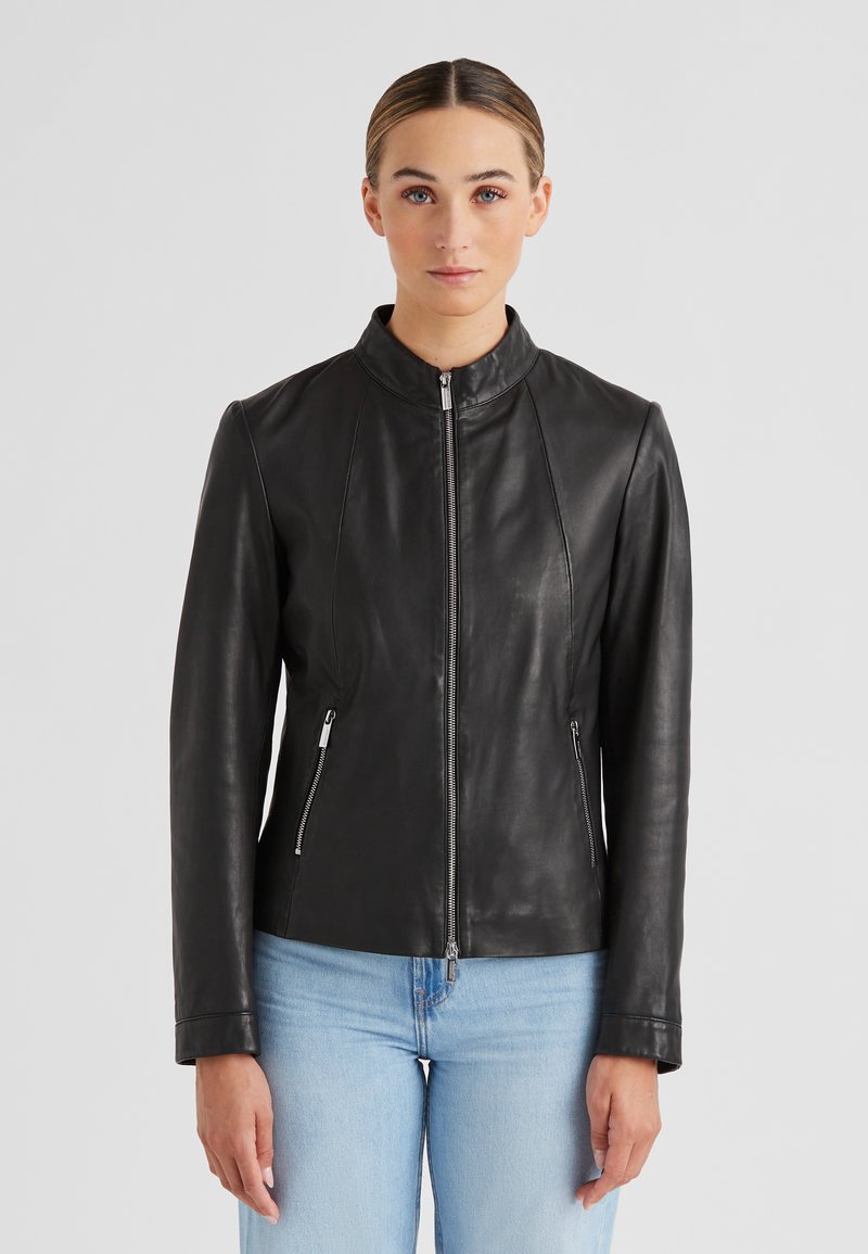 Schwarze Lederjacke mit Stehkragen, tailliertem Schnitt, sichtbarem Reißverschluss und zwei seitlichen Reißverschlusstaschen. Glatte Textur.